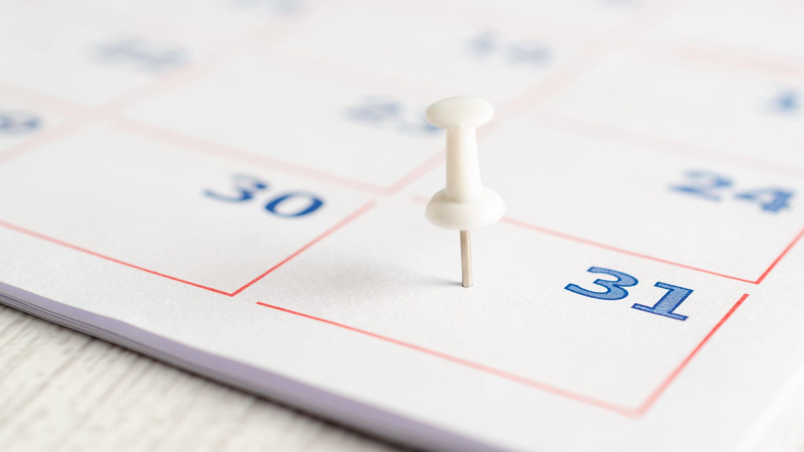 White thumbtack on a calendar page.